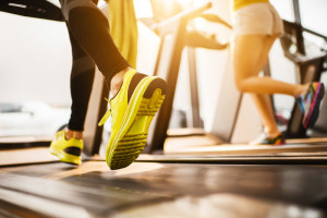 Unrecognizable people running on treadmills in a gym.